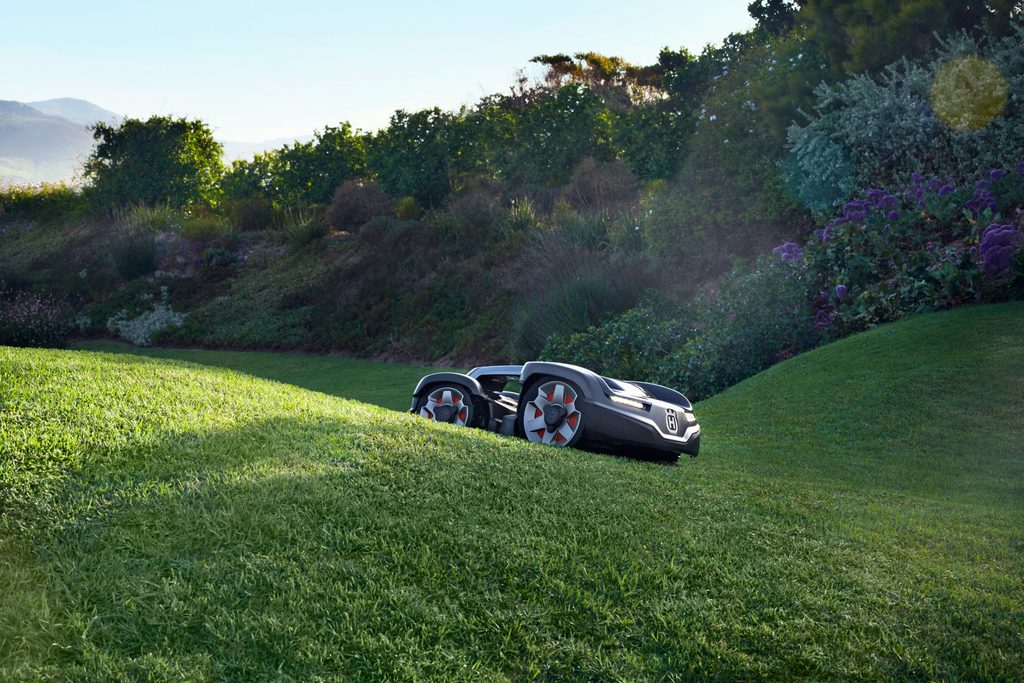 Husqvarna Automower robotic lawn mower cutting grass on a green lawn, available at Grafton Power Products in the Clarence Valley.