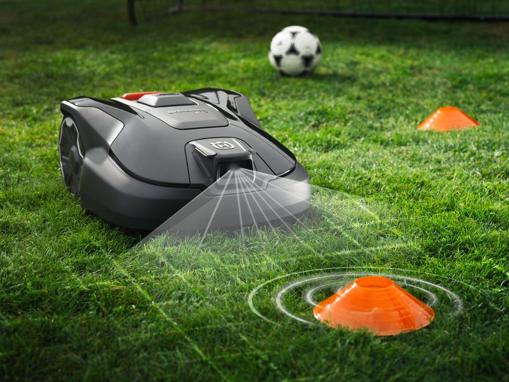 Husqvarna Automower 312V smart robotic mower cutting grass in a medium-sized suburban backyard, supplied by Grafton Power Products.